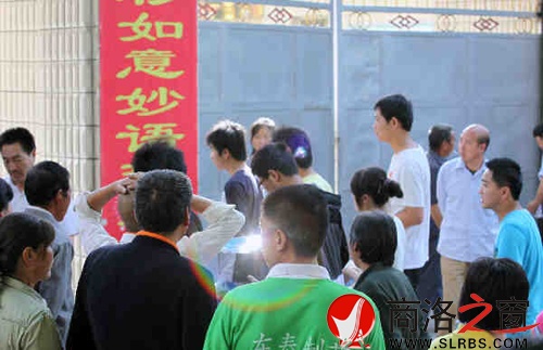家們送考生進(jìn)入考場時，一縷光環(huán)閃現(xiàn)鏡頭中，這也許就是人們的理想與期待.jpg